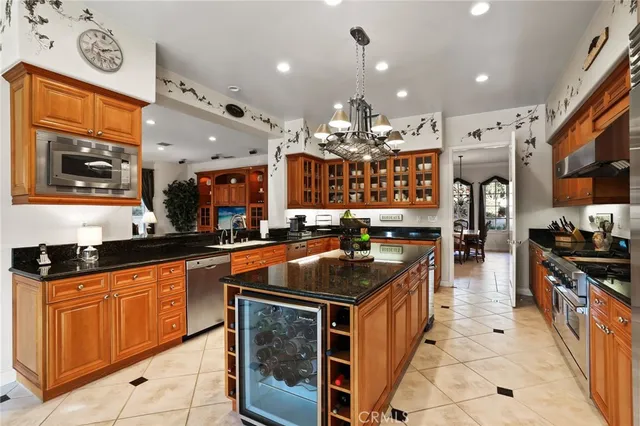 a kitchen with stainless steel appliances granite countertop a stove a sink dishwasher and a microwave oven with large countertops
