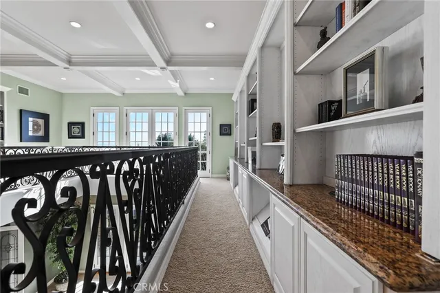 a spacious bedroom with a bed painting on wall and windows