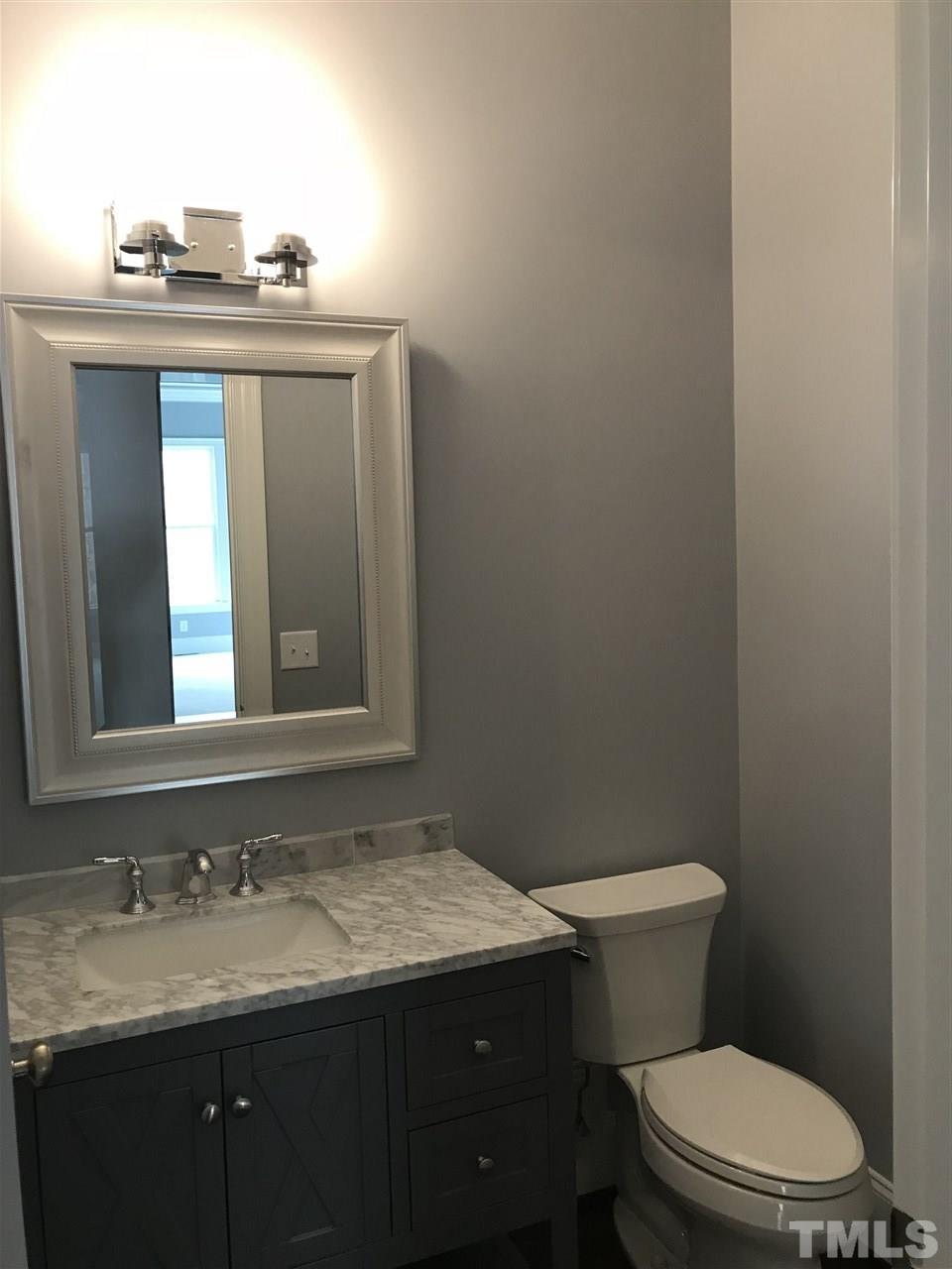 8707 Duckview Court Raleigh, NC 27613 - Photo 15 of 25 a bathroom with a granite countertop toilet sink and mirror