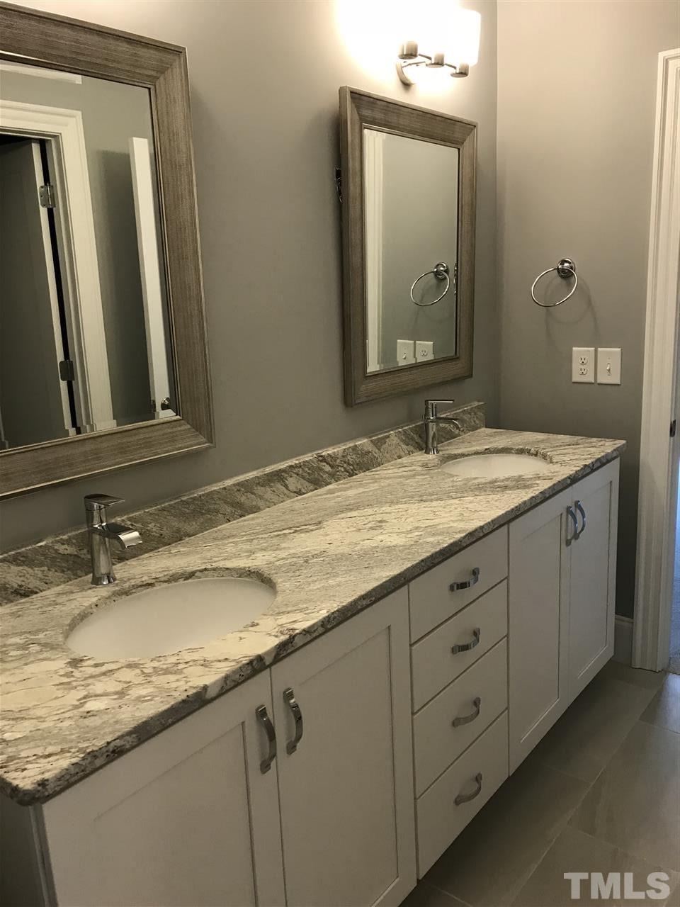 8707 Duckview Court Raleigh, NC 27613 - Photo 17 of 25 a bathroom with a granite countertop sink vanity and mirror