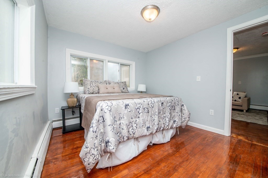 452 Tecumseh Street Fall River, MA 02721 - Photo 19 of 26 a bedroom with a bed and wooden floor
