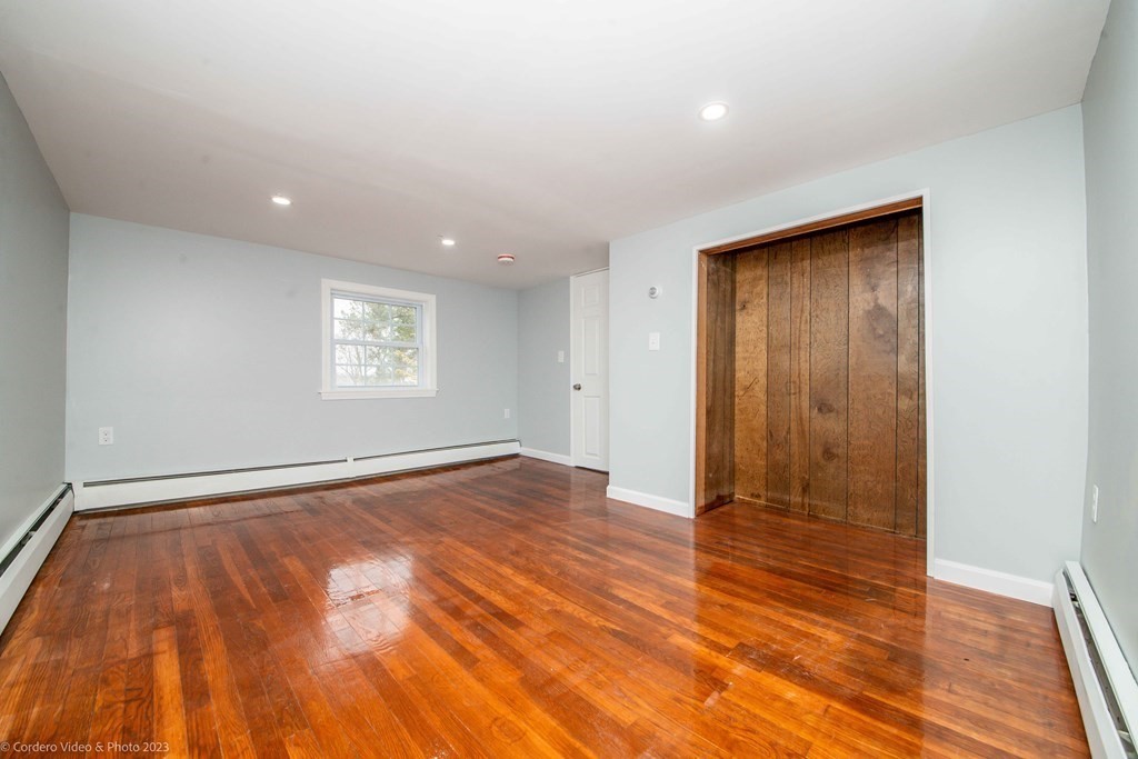 452 Tecumseh Street Fall River, MA 02721 - Photo 23 of 26 an empty room with wooden floor and windows