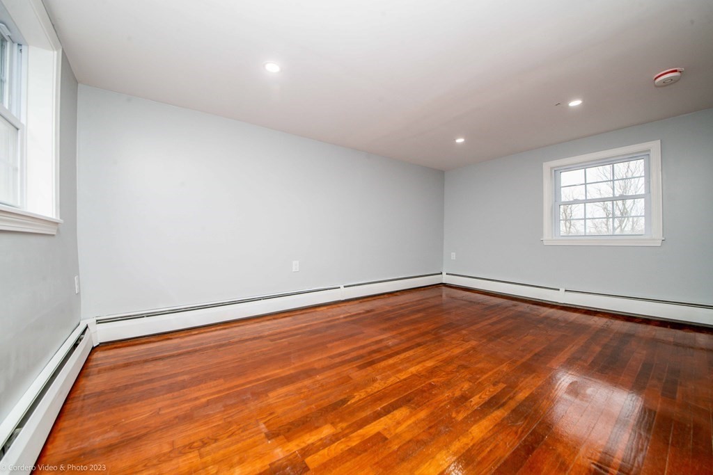 452 Tecumseh Street Fall River, MA 02721 - Photo 25 of 26 an empty room with wooden floor and windows