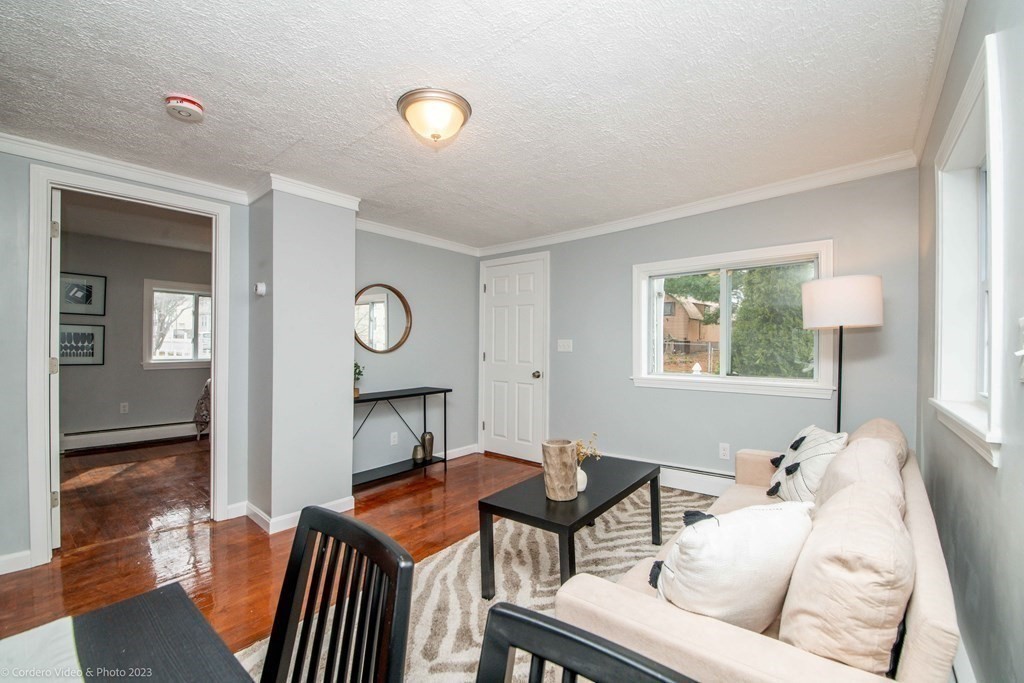 452 Tecumseh Street Fall River, MA 02721 - Photo 10 of 26 a living room with furniture a table and wooden floor