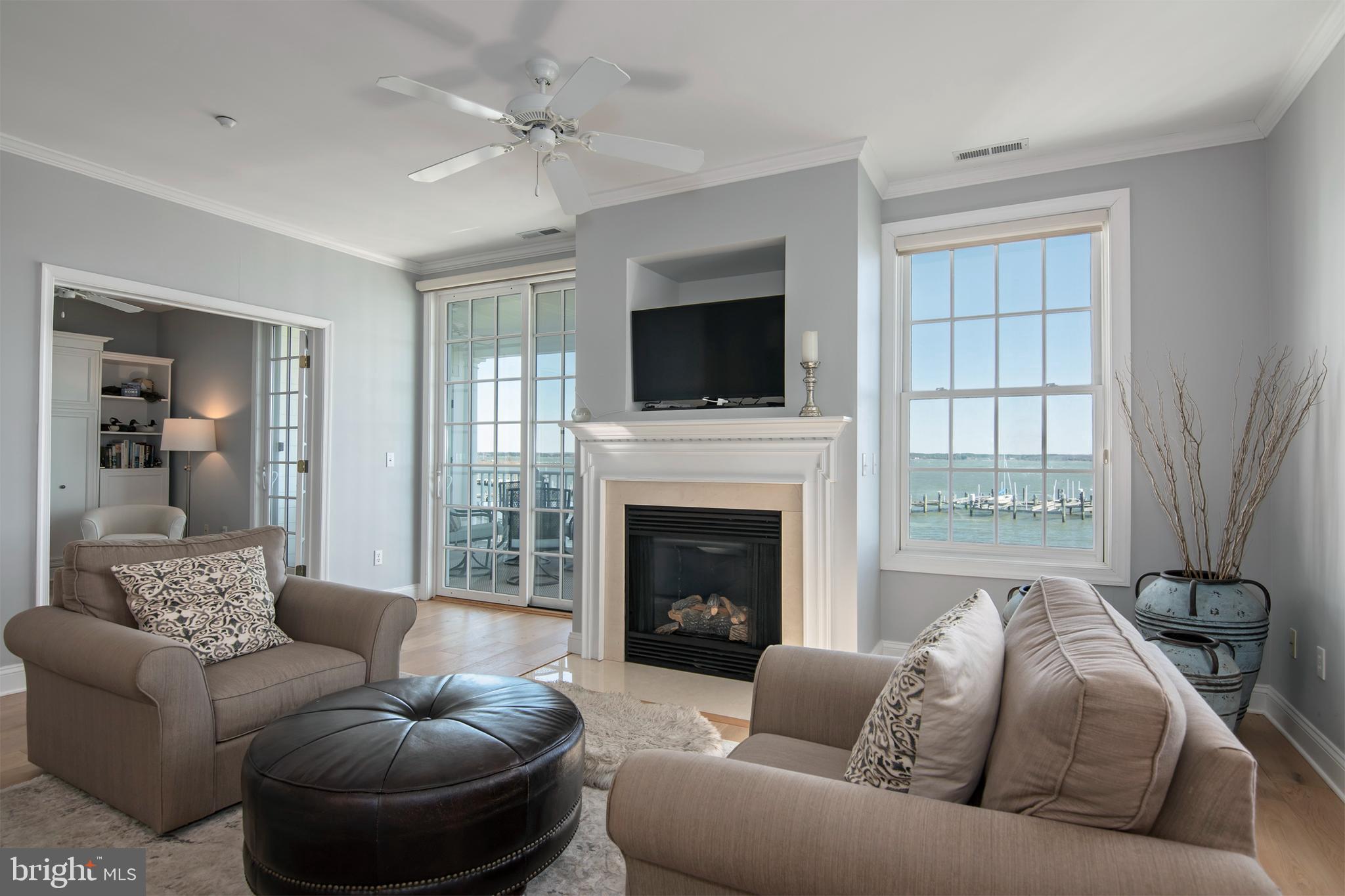 3 Oakley Street, Unit 201 Cambridge, MD 21613 - Photo 11 of 41 a living room with furniture a flat screen tv and a fireplace