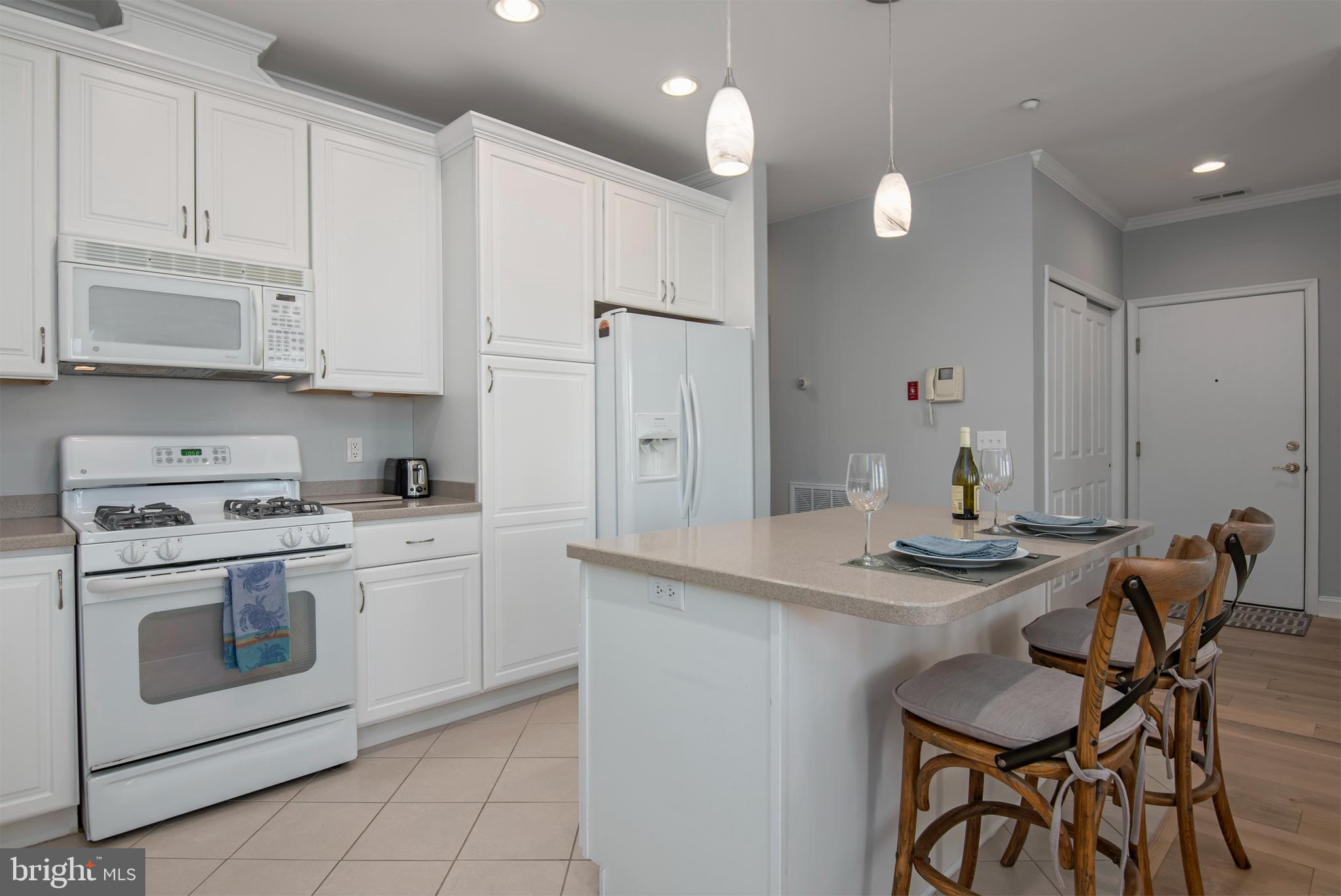 3 Oakley Street, Unit 201 Cambridge, MD 21613 - Photo 13 of 41 a kitchen with stainless steel appliances granite countertop a white cabinets and a stove