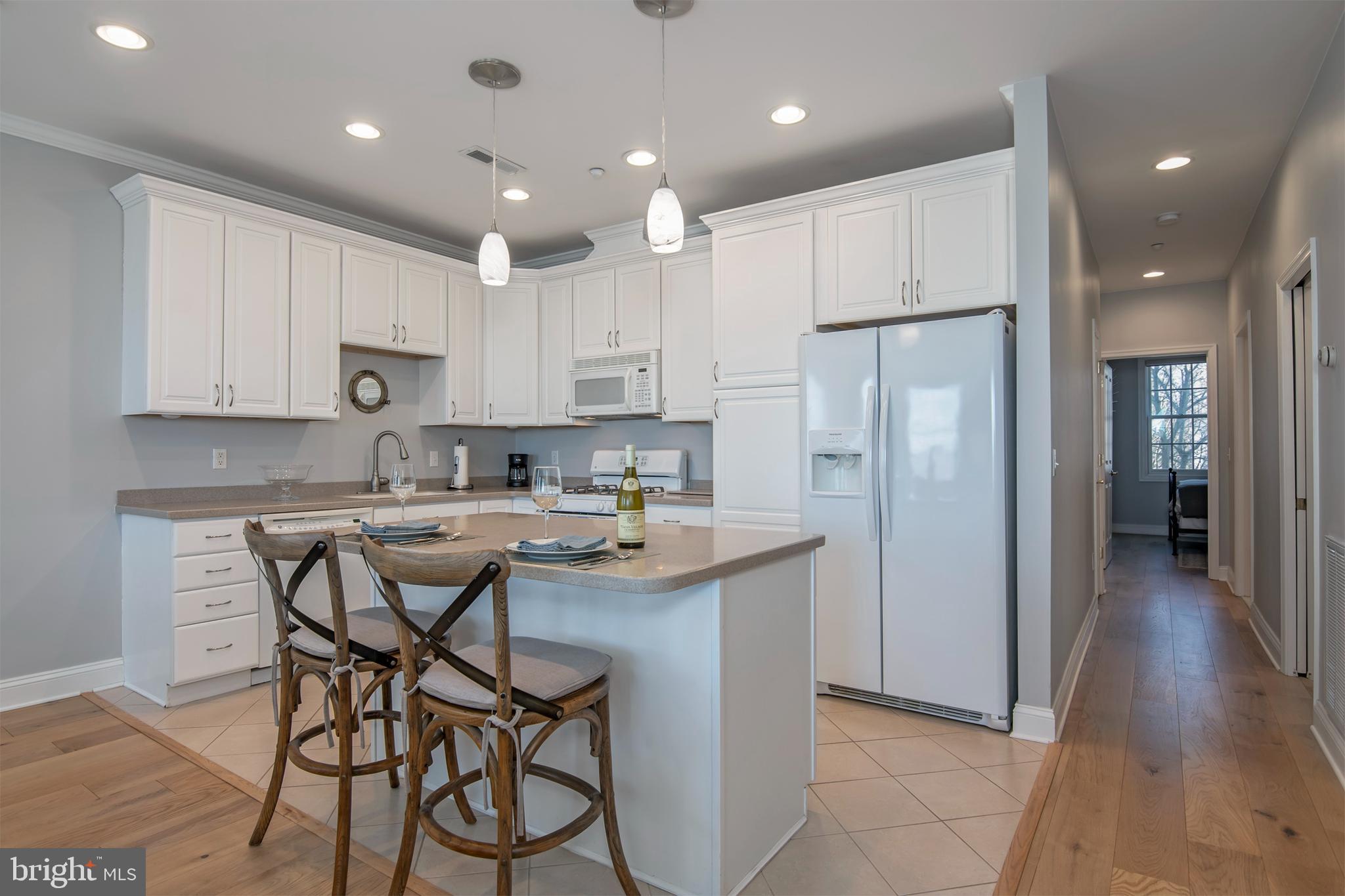 3 Oakley Street, Unit 201 Cambridge, MD 21613 - Photo 15 of 41 a kitchen with kitchen island cabinets and a refrigerator