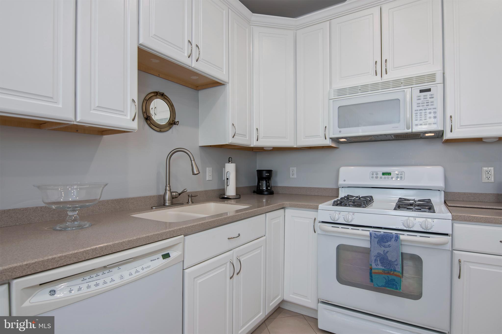 3 Oakley Street, Unit 201 Cambridge, MD 21613 - Photo 17 of 41 a kitchen with white cabinets stainless steel appliances and sink