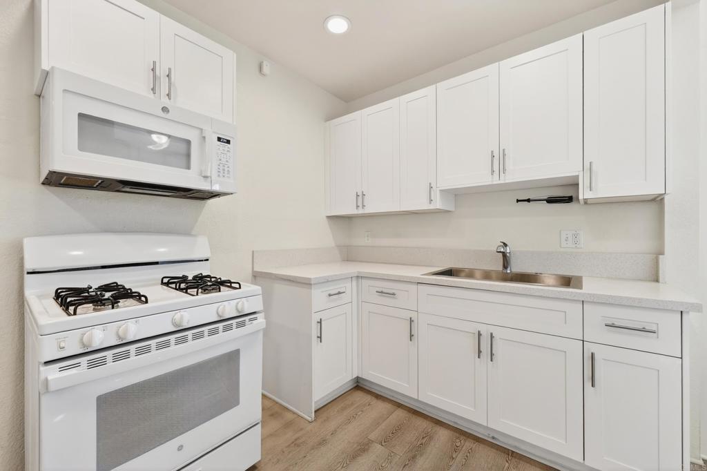 1530 East Appleton Street Long Beach, CA 90802 - Photo 32 of 61 a kitchen with white cabinets and white appliances