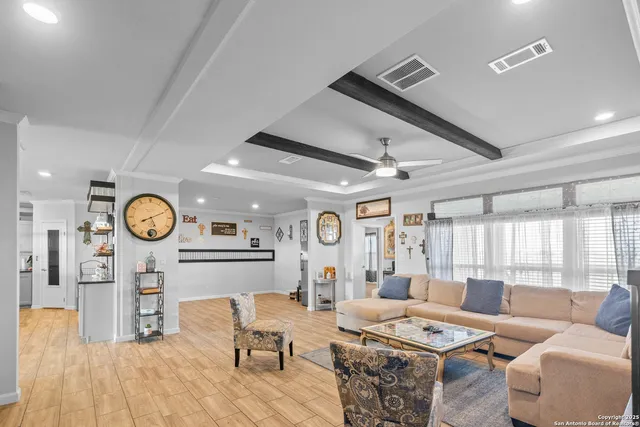 a living room with furniture a clock and a large window