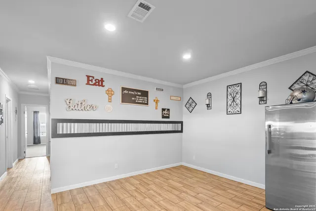 a view of a refrigerator in kitchen and an empty room
