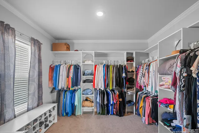 a view of walk in closet with clothes