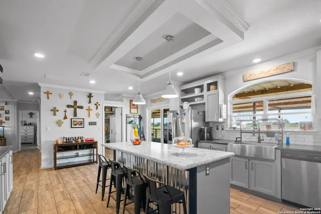 a kitchen with stainless steel appliances kitchen island granite countertop a table chairs in it and wooden floors
