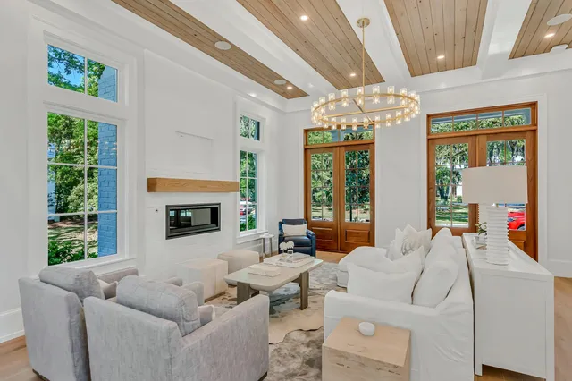 a kitchen with stainless steel appliances granite countertop a stove a refrigerator a sink and white cabinets with wooden floor