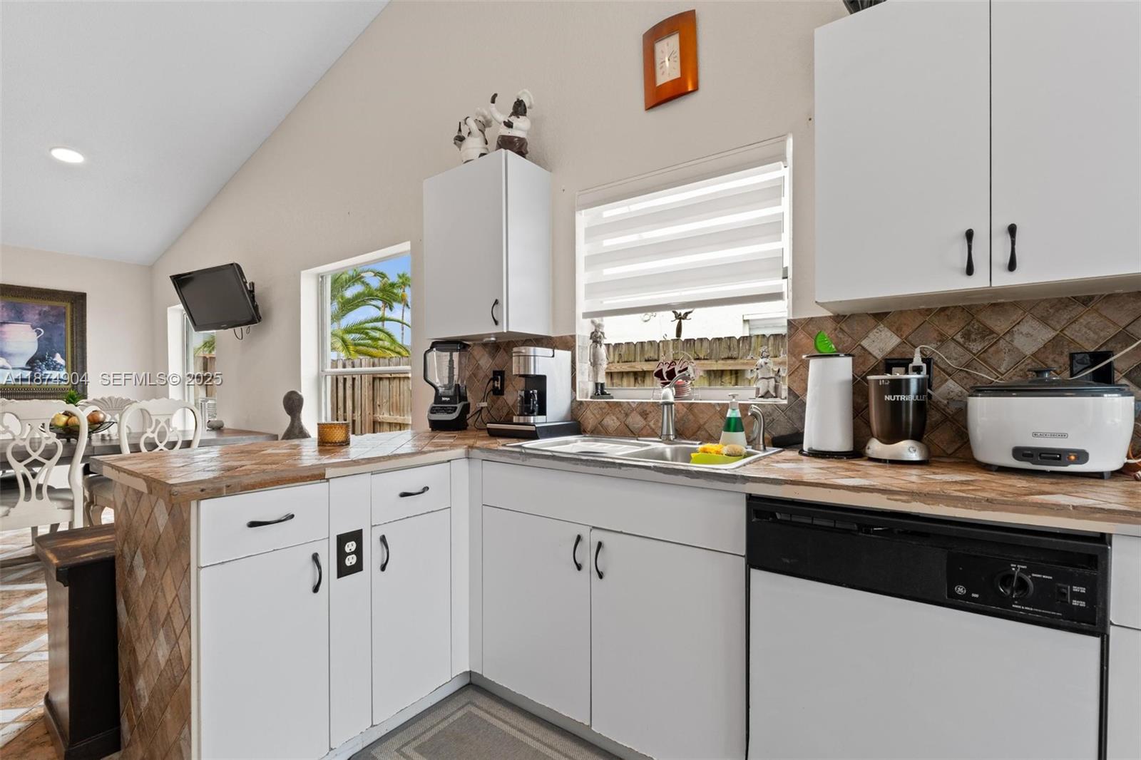 16034 Southwest 83rd Terrace Miami, FL 33193 - Photo 8 of 30 a kitchen with a sink a window appliances and cabinets