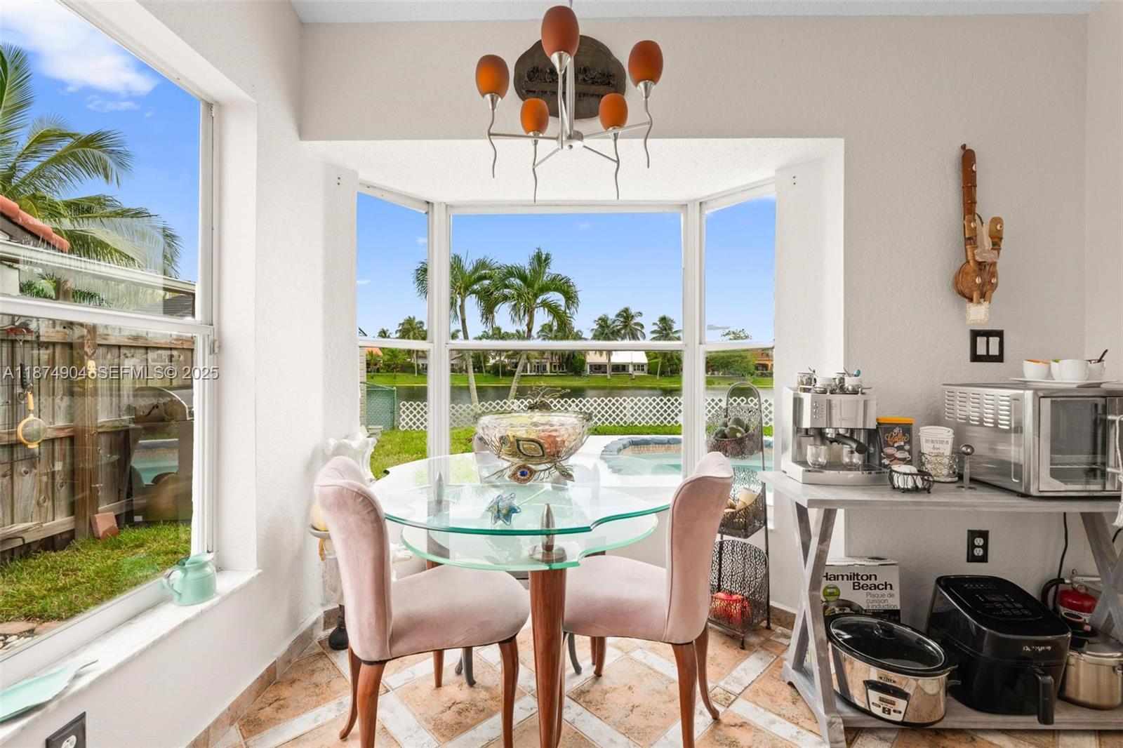 16034 Southwest 83rd Terrace Miami, FL 33193 - Photo 10 of 30 a dining room with furniture a large window and potted plants