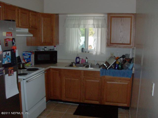 7344 Melvin Road Jacksonville, FL 32210 - Photo 4 of 11 a kitchen with stainless steel appliances a refrigerator sink and cabinets