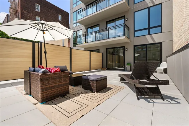 a view of a patio with a dining table and chairs under an umbrella
