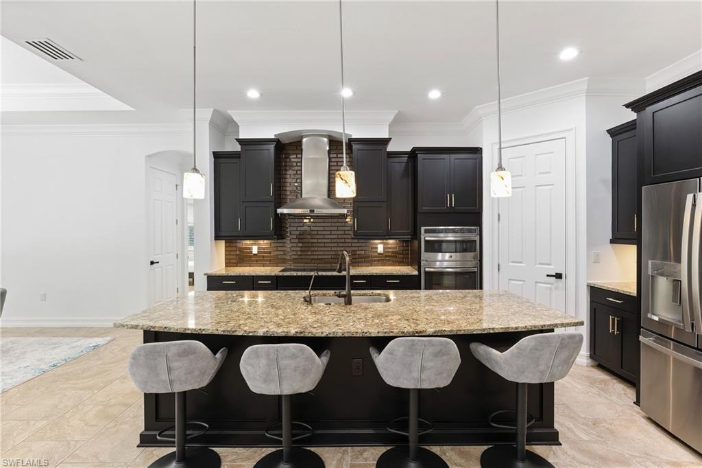 1584 Mockingbird Drive Naples, FL 34120 - Photo 18 of 40 a kitchen with granite countertop a table chairs stove a refrigerator and cabinets