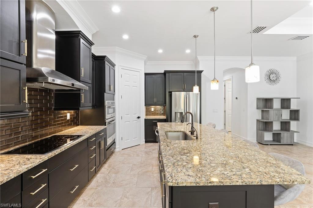1584 Mockingbird Drive Naples, FL 34120 - Photo 20 of 40 a kitchen with stainless steel appliances kitchen island granite countertop a stove and refrigerator