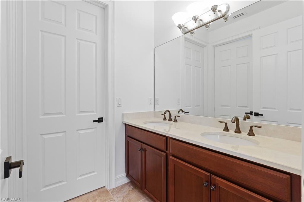 1584 Mockingbird Drive Naples, FL 34120 - Photo 27 of 40 a bathroom with a sink and a mirror