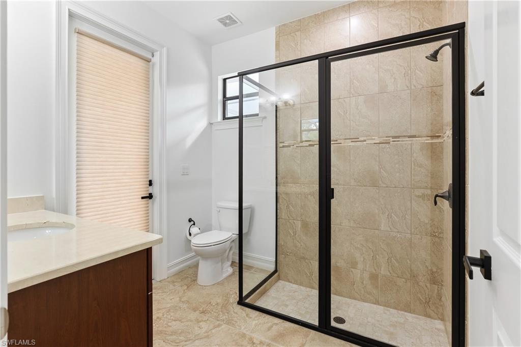1584 Mockingbird Drive Naples, FL 34120 - Photo 32 of 40 a bathroom with a glass shower door and a toilet