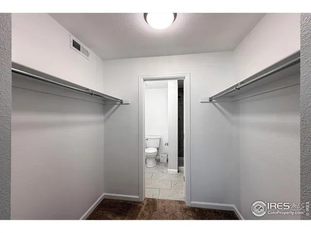 a bathroom with a granite countertop sink a toilet and a mirror