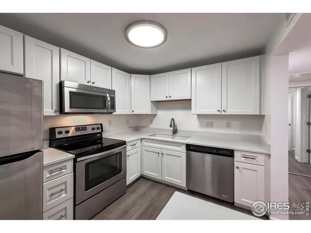 a kitchen with cabinets stainless steel appliances and sink
