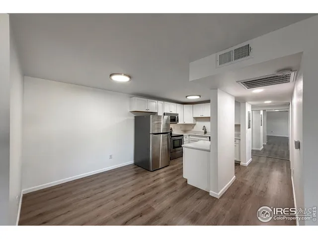 a kitchen with refrigerator cabinets and wooden floor