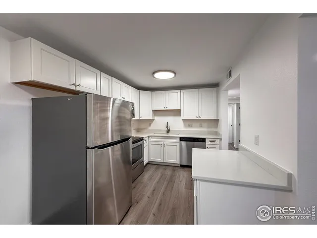 a kitchen with cabinets stainless steel appliances and sink