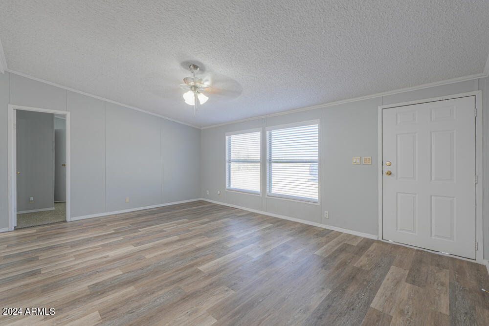 8926 North Thunderbird Road Maricopa, AZ 85139 - Photo 27 of 49 a view of empty room with wooden floor and fan