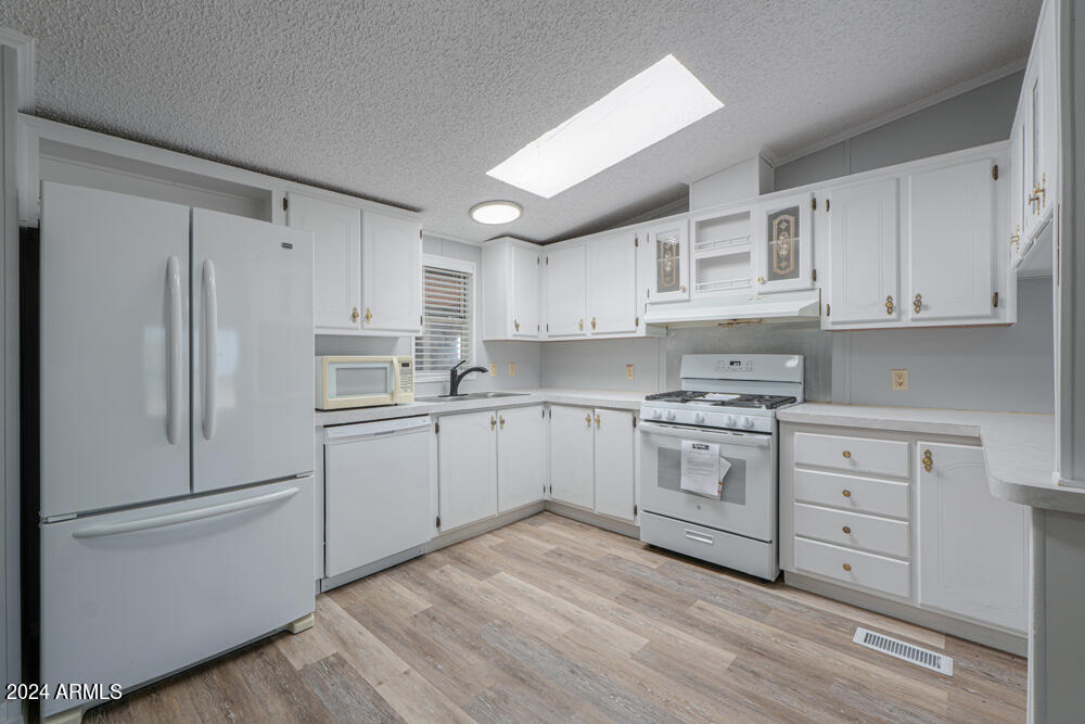8926 North Thunderbird Road Maricopa, AZ 85139 - Photo 31 of 49 a kitchen with white cabinets white stainless steel appliances and sink