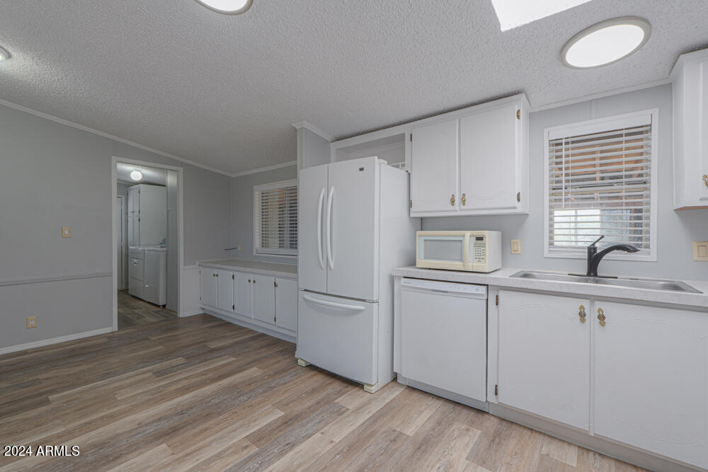 8926 North Thunderbird Road Maricopa, AZ 85139 - Photo 34 of 49 a kitchen with white cabinets and white appliances