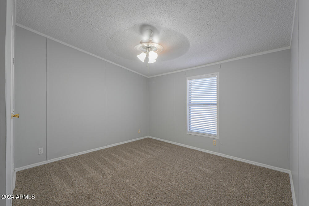 8926 North Thunderbird Road Maricopa, AZ 85139 - Photo 37 of 49 an empty room with a window and a chandelier fan