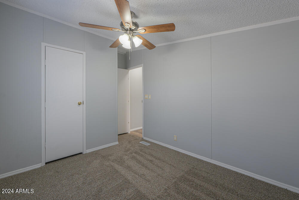 8926 North Thunderbird Road Maricopa, AZ 85139 - Photo 40 of 49 an empty room with a chandelier fan