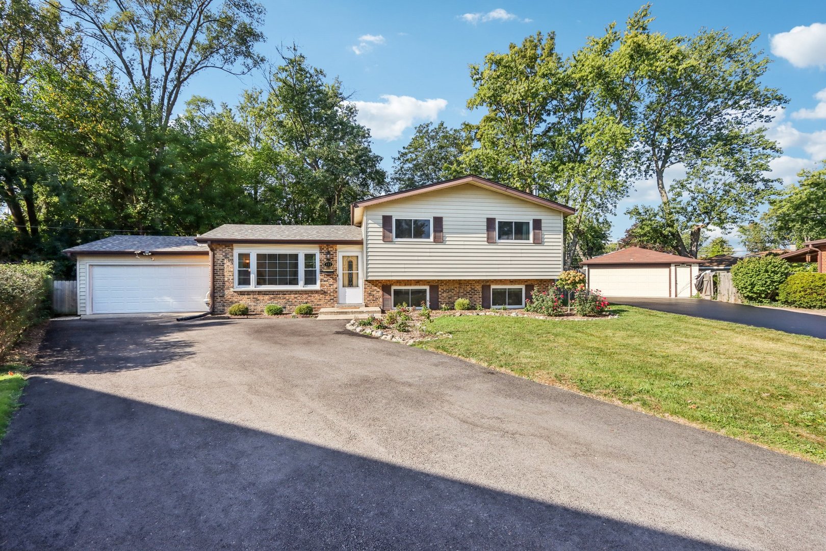 a view of a house with a yard and large tree