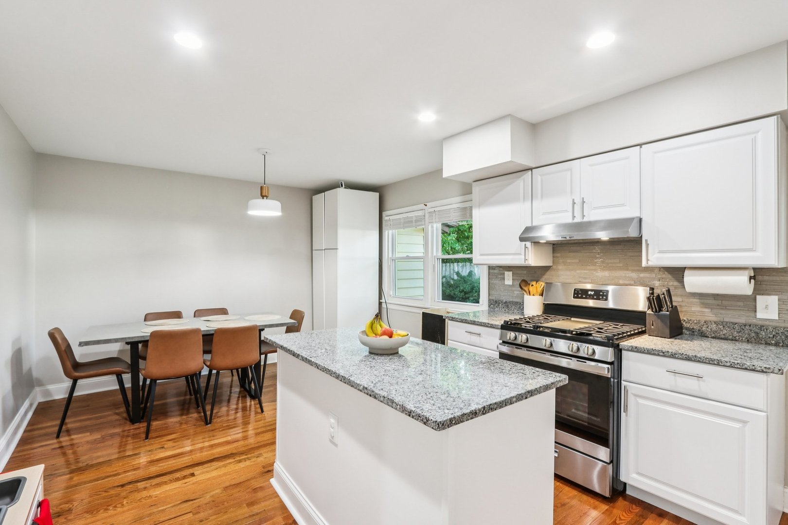 461 Ardmore Terrace Addison, IL 60101 - Photo 6 of 29 a kitchen with stainless steel appliances granite countertop a stove top oven a sink a dining table and chairs