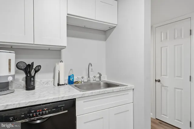 a kitchen with white cabinets and a sink