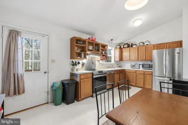 a kitchen with stainless steel appliances granite countertop a refrigerator and a stove top oven