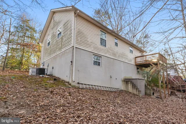 a view of a white house with a large tree