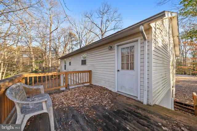 a view of backyard with deck and outdoor seating