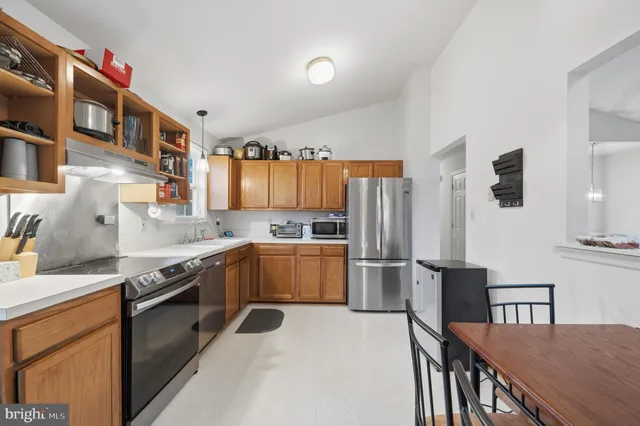 a kitchen with granite countertop a sink stove and refrigerator