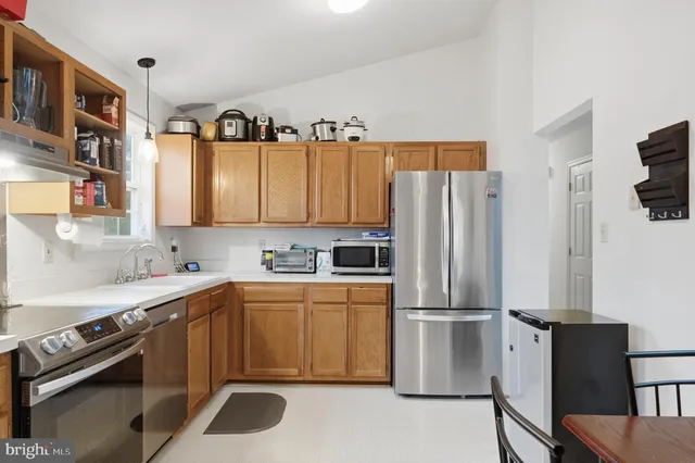 a kitchen with a sink a refrigerator and cabinets