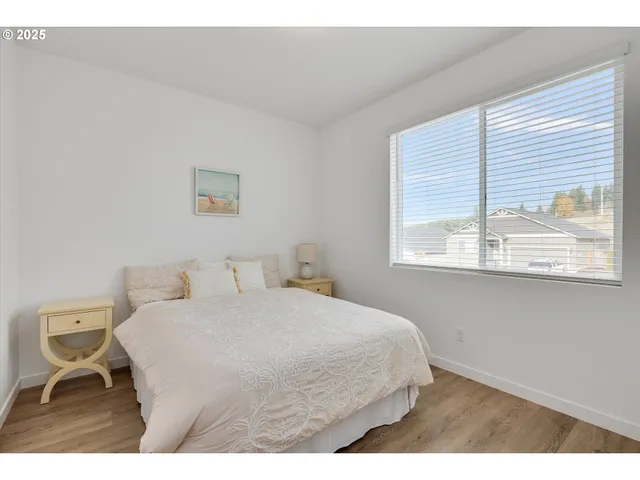 a bedroom with a bed and a large window