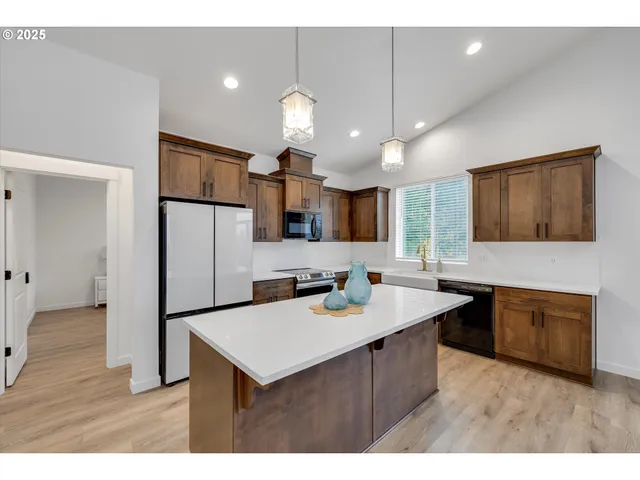 a kitchen with kitchen island a sink stainless steel appliances and refrigerator