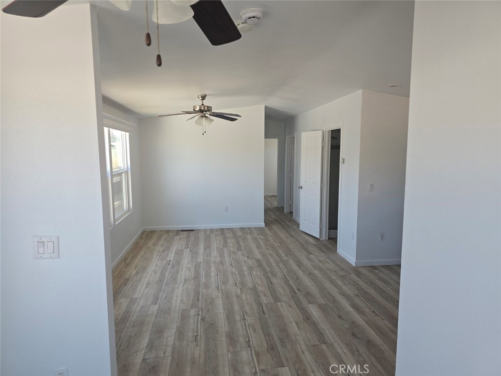 13096 Blackbird Street, Unit 164 Garden Grove, CA 92843 - Photo 12 of 19 an empty room with wooden floor cabinet and windows