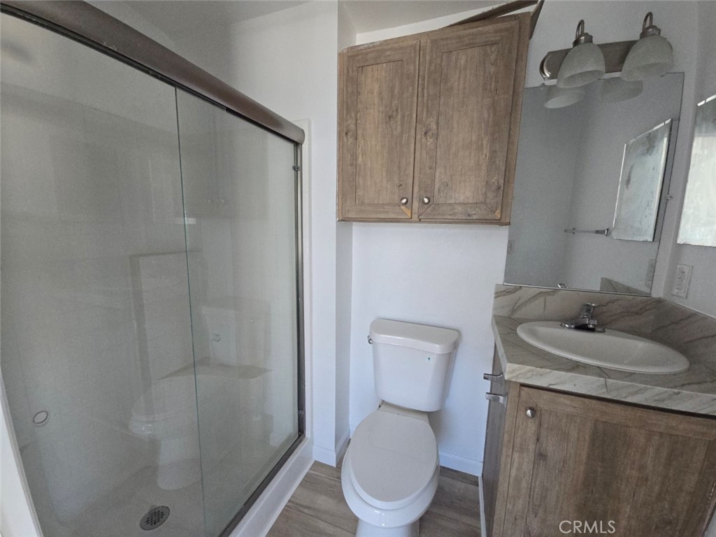 13096 Blackbird Street, Unit 164 Garden Grove, CA 92843 - Photo 15 of 19 a white toilet sitting next to a bathroom sink