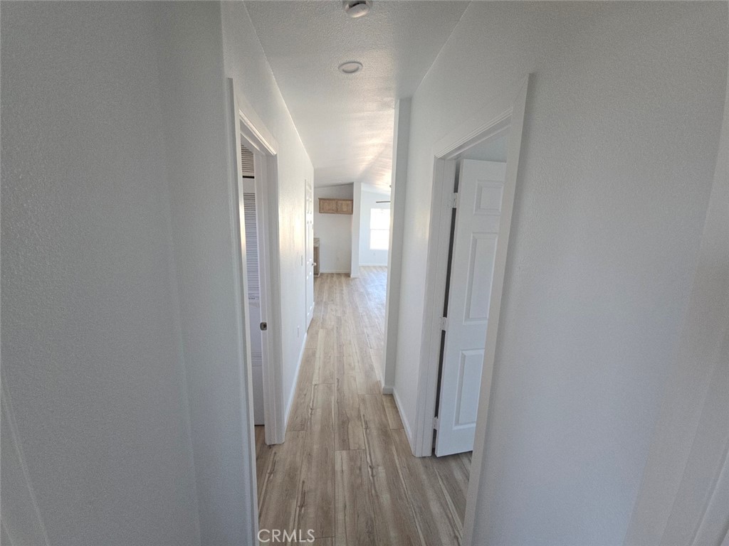 13096 Blackbird Street, Unit 164 Garden Grove, CA 92843 - Photo 17 of 19 a view of a hallway with wooden floor and entryway