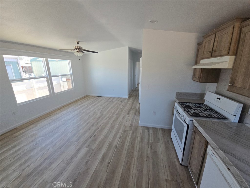 13096 Blackbird Street, Unit 164 Garden Grove, CA 92843 - Photo 4 of 19 a kitchen with wooden floors and a stove top oven