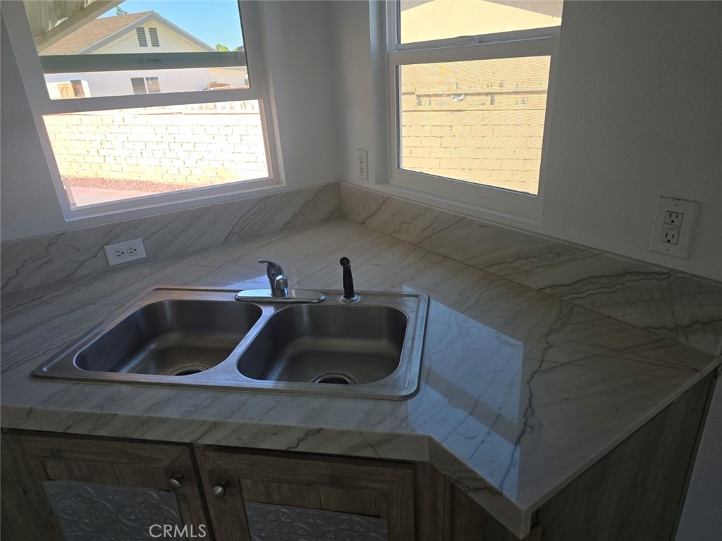 13096 Blackbird Street, Unit 164 Garden Grove, CA 92843 - Photo 6 of 19 a kitchen with a sink cabinets a window and a sink